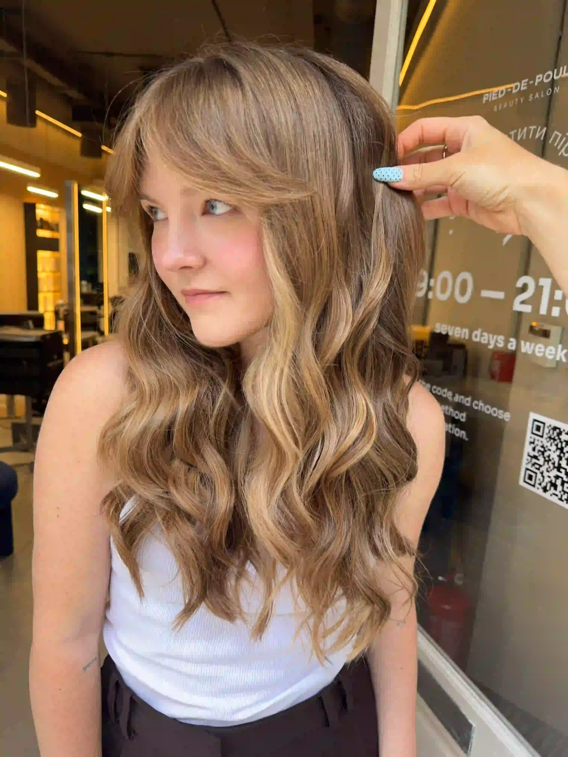 Balayage highlights on long wavy hair with soft face-framing strands